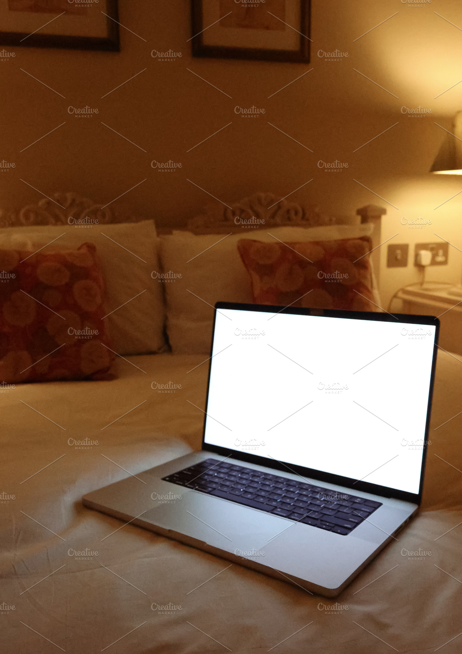 Laptop with a blank white screen resting on a hotel bed, ideal for displaying t, a Photo by Studio ANNA