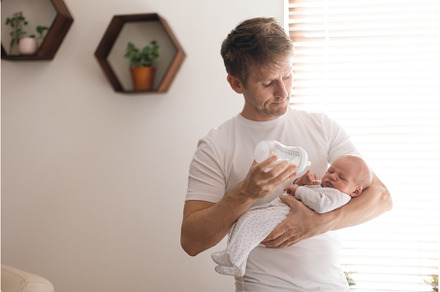 Father holding and feeding his, a Person Photo by HalfPoint