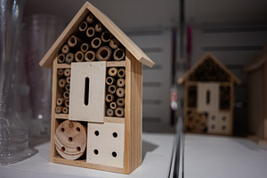 Wooden insect house on display in a store setting in close-up view, a Photo by AS photostudio