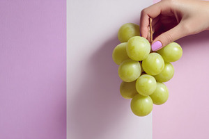 Hand holding green grapes, a Photo by Beautiful things