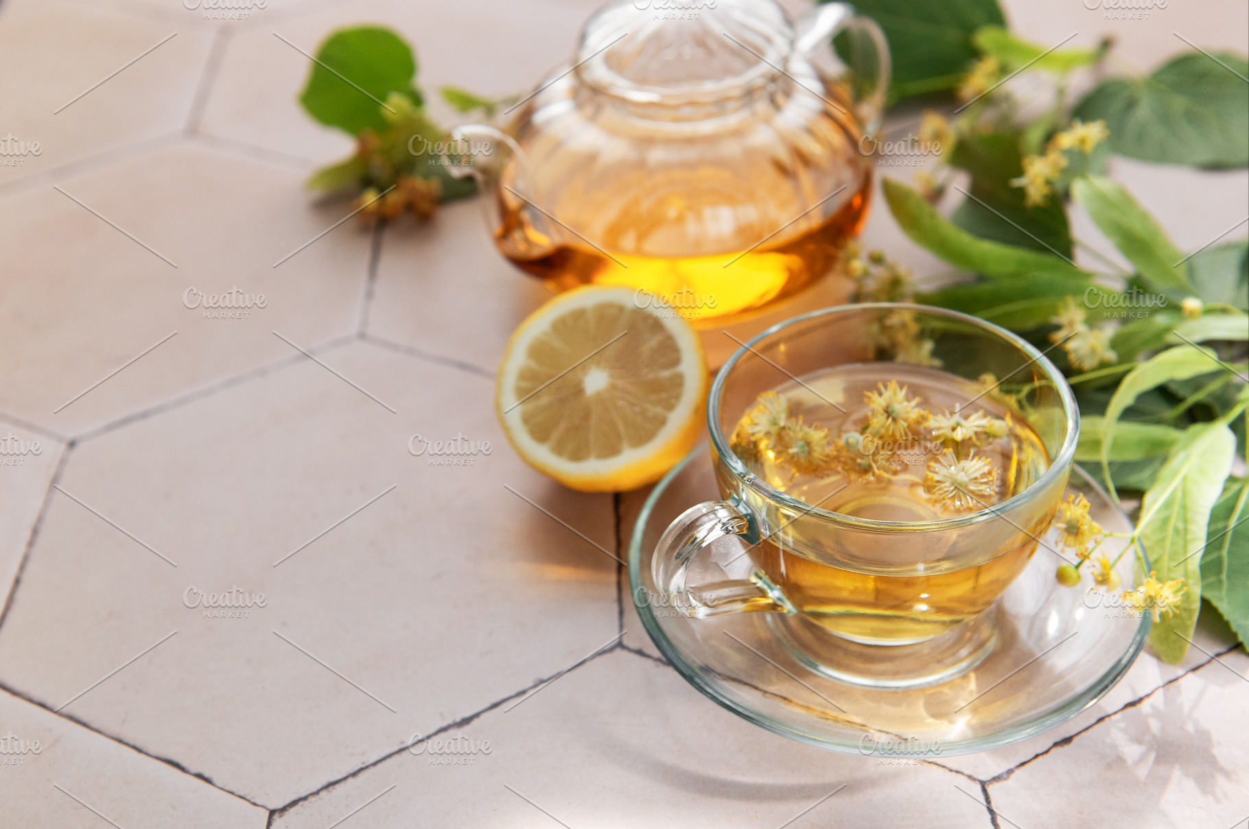 Linden herbal tea brewing with fresh lemon and natural flowers, a Food & Drink Photo by Olena Rudo