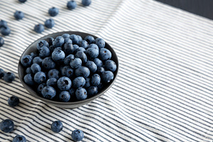 Raw Organic Blueberries in a Bowl, side view. Copy space., a Food & Drink Photo by LiudmylaChuhunova