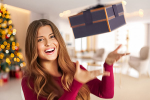 Happy woman catching a Christmas gift, celebrating holiday seaso, a Person Photo by Studio ANNA