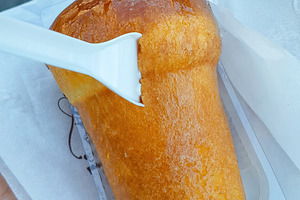 Rum baba being eaten with small white plastic fork, a Food & Drink Photo by Antonio Gravante Market