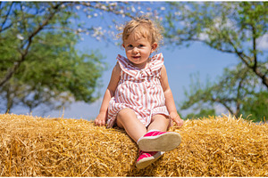 The child is sitting on a pile of, a Nature Photo by yanadjana
