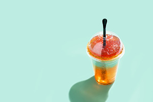 Colorful frozen slush drink with straw and hard sunlight on pastel background, a Food & Drink Photo by etorres69