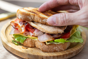 Hand Holding Fresh Club Sandwich with Bacon, Ham, Cheese and Grilled Chicken, a Food & Drink Photo by etorres69