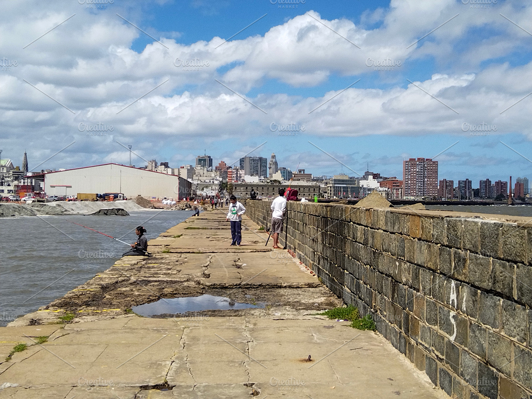 People walking and fishing on a long urban pier, montevideo, uru, an Architecture Photo by DanFLCreativo