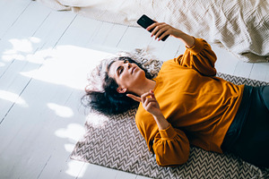 Woman lying down floor in livingroom, a Person Photo by hitdelight