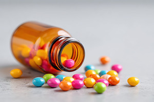 Colorful candies spilling from a glass bottle, a Health & Medical Photo by AlyaAnd