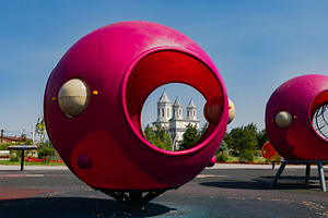 Bright pink playground structures with circular openings, set in a park, with a, a Sports & Recreation Photo by Ales Munt