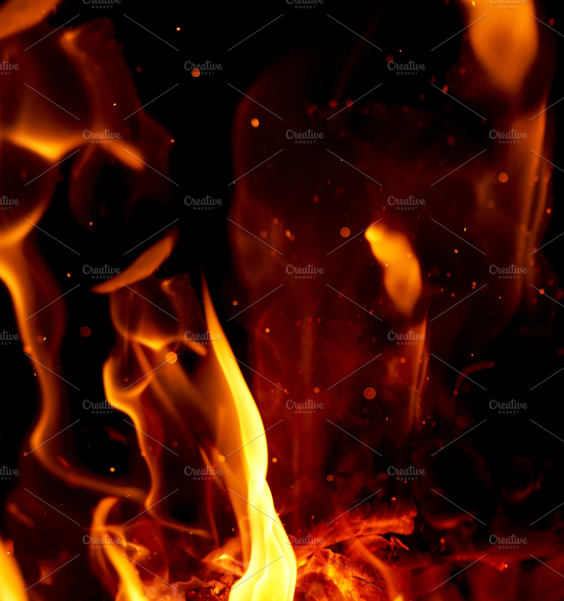 Intense tongues of orange and yellow flame, small glowing sparks, an Abstract Photo by ndanko