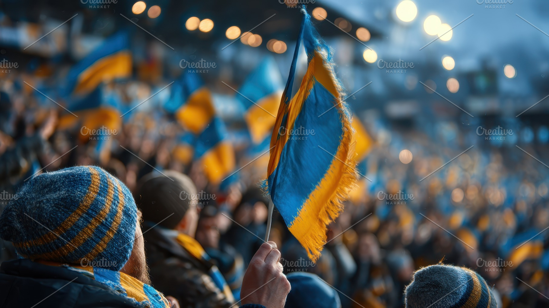 Fan holds Ukrainian flag at stadium, a Photo by Pixeness Studio