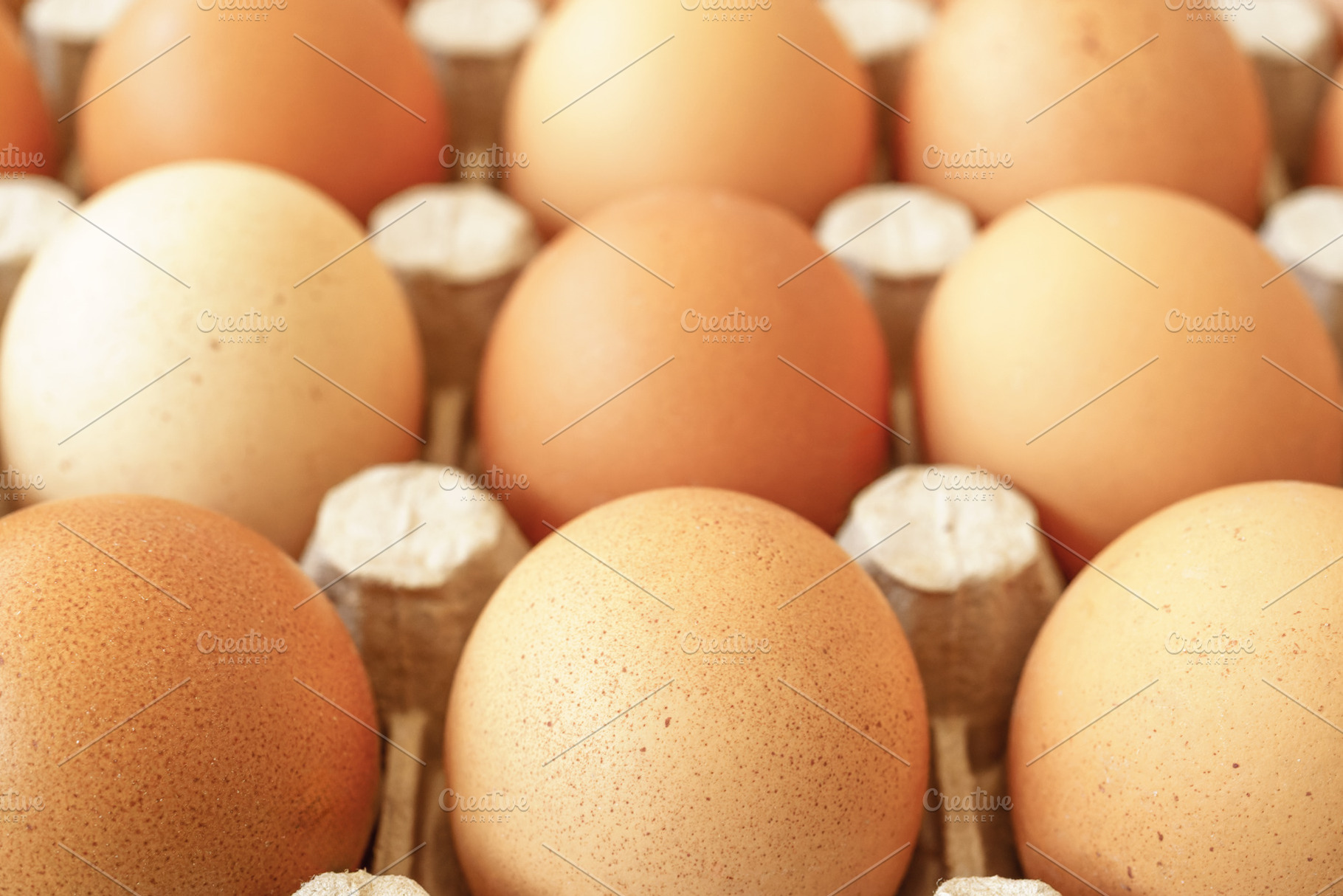 Brown chicken eggs in a cardboard tray on a rustic wood background for farm and, a Food & Drink Photo by Eugene_Photo
