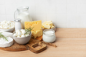 Assortment of fresh dairy products on wooden table, a Food & Drink Photo by Olena Rudo