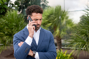 Businessman talking on smartphone outside modern office, a Business Photo by etorres69