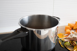 Empty stainless steel pot on stove with chopped vegetables on kitchen counter, a Food & Drink Photo by etorres69