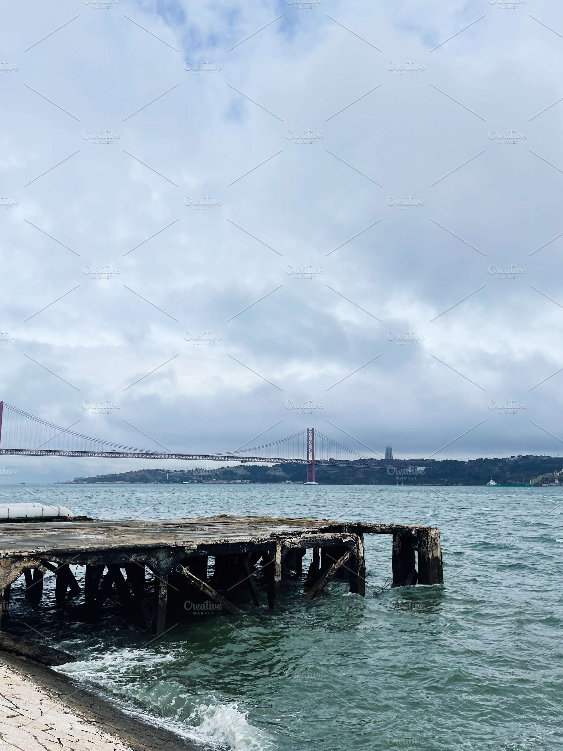 Lisbon harbor with red suspension bridge and weathered pier over calm sea and c, a Photo by AS photostudio