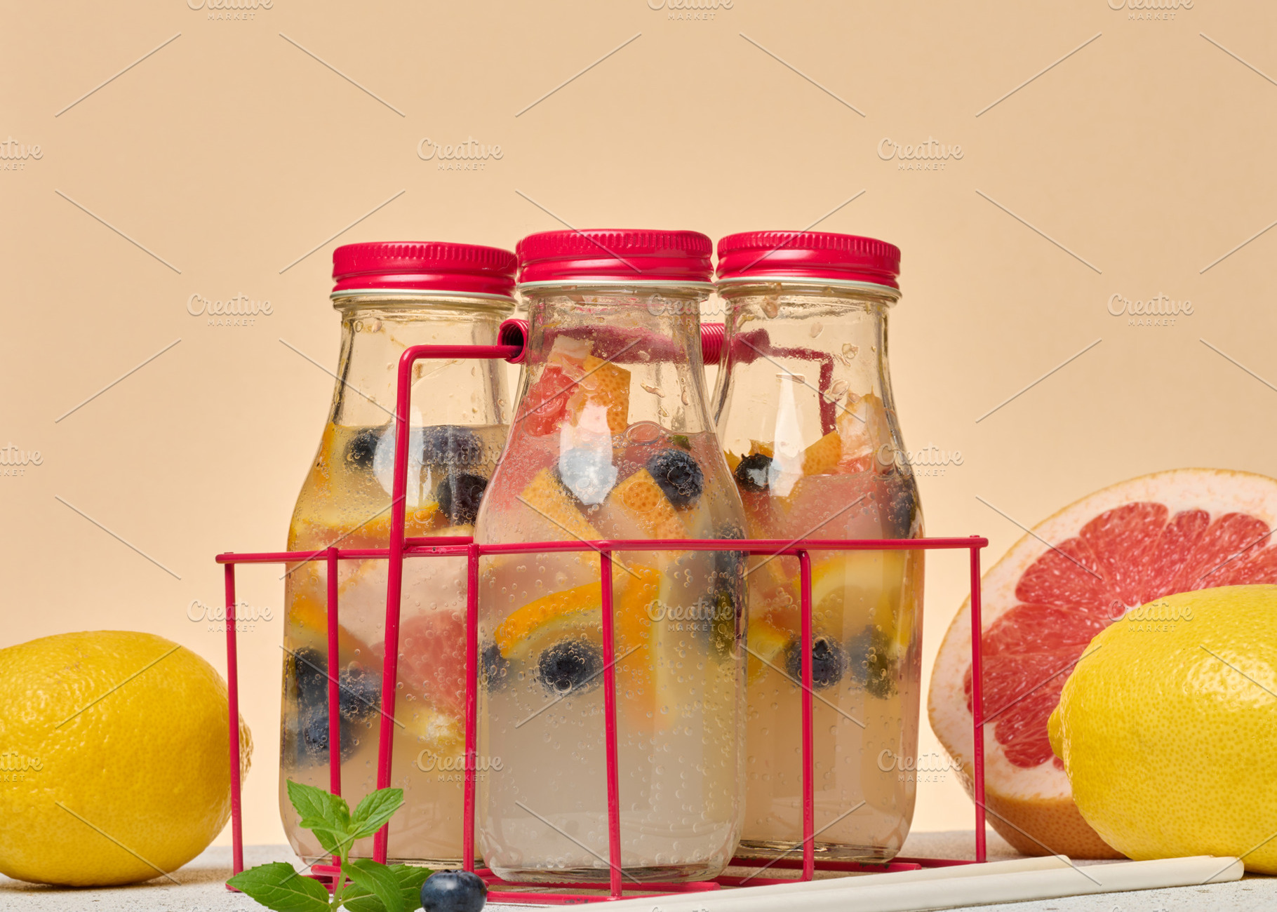 Glass bottles with red lids, filled with detox water infused wit, a Food & Drink Photo by ndanko
