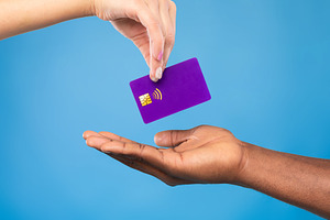 Cropped view of black man taking credit card from millennial woman on blue stud, a Photo by Prostock-Studio