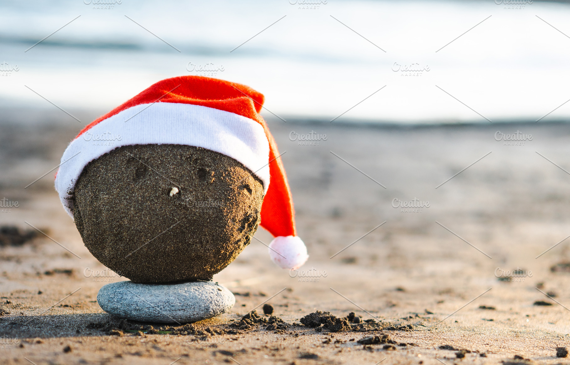 Christmas sand sculpture with Santa hat on the beach, a Holiday Photo by etorres69
