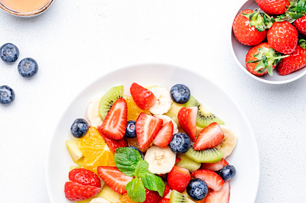 Fresh summer fruit and berry salad with strawberries, blueberrie, a Food & Drink Photo by 5PH