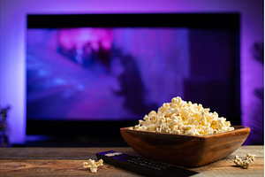 A wooden bowl of popcorn and remote, a Technology Photo by Budarinphoto