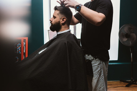 Side view of men's haircut process, hairdresser cutting hair of, a Person Photo by progressman