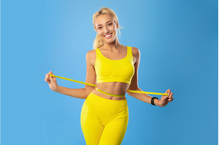 Smiling Young Woman Measuring Waist, a Person Photo by Prostock-Studio