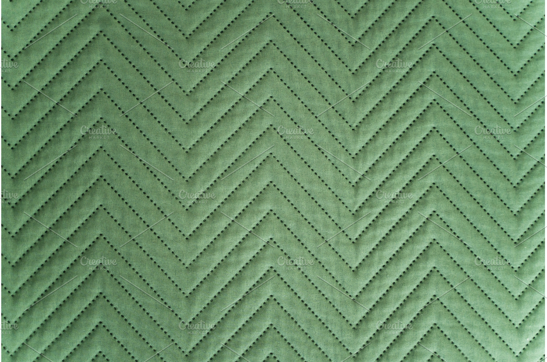 Close-up of quilted green fabric, a Background Photo by volodymyrshtun13795