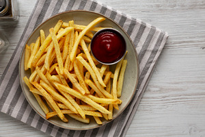 Homemade French Fries and Ketchup on a Plate, top view. Space fo, a Food & Drink Photo by LiudmylaChuhunova