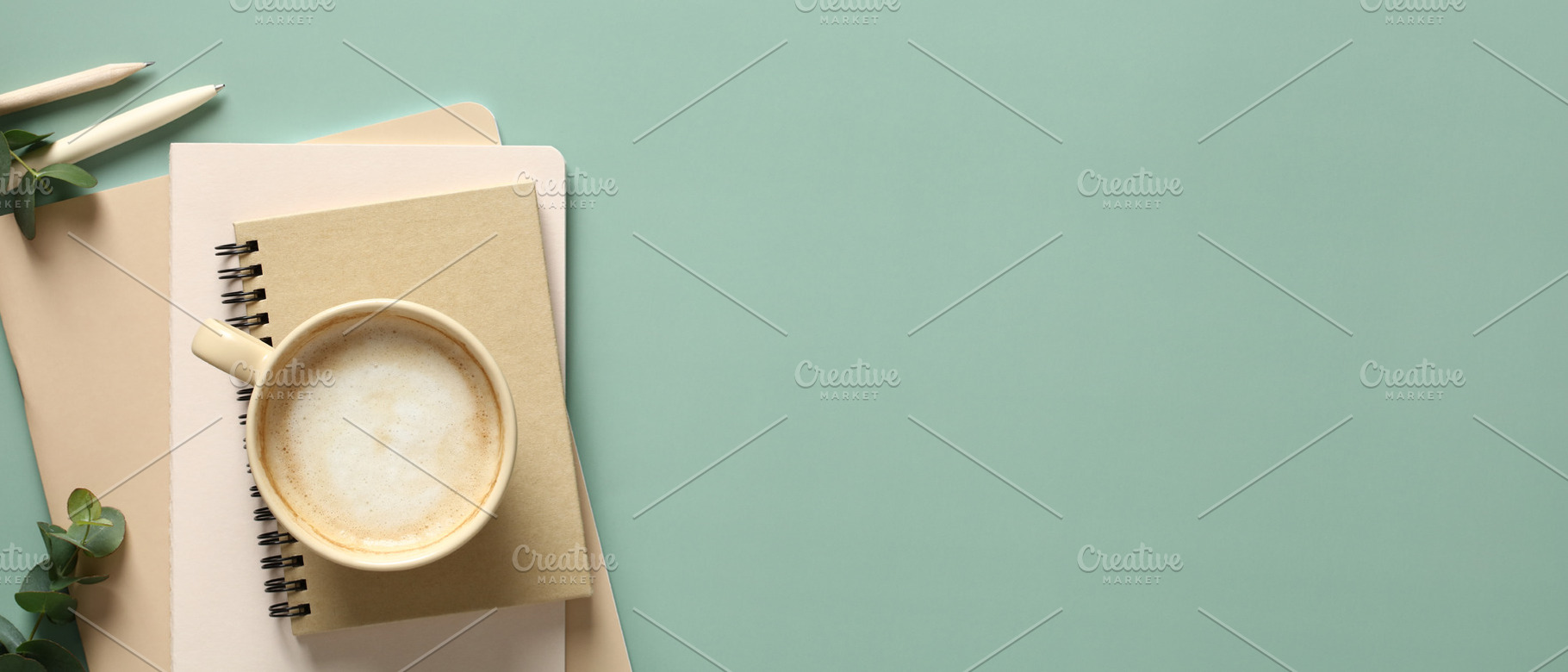Banner with cup of coffee, stack of paper notebooks and eucalyptus leaves on gr, a Business Photo by photoguns