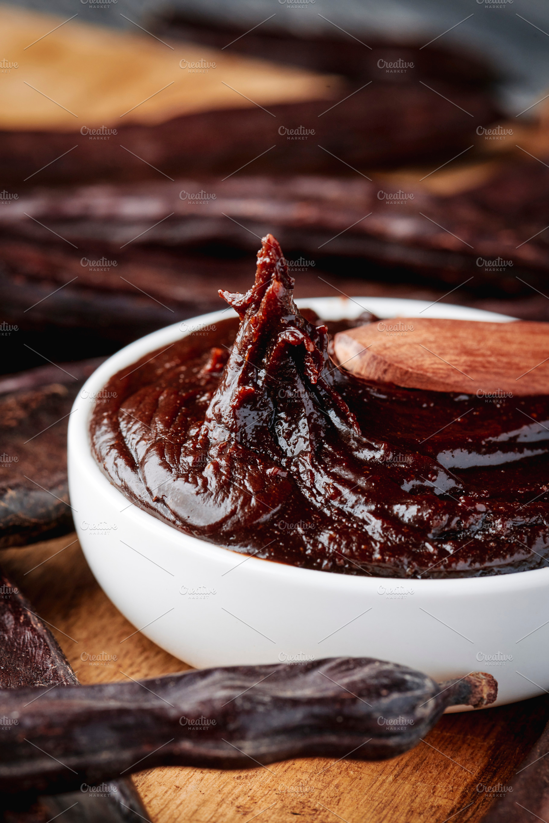 a spoon lifts carob cream from a white bowl, a Photo by Nito
