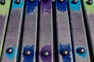 Vibrant close-up of metallic xylophone bars with colorful painted accents, perf, a Person Photo by Ales Munt