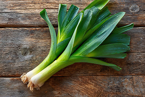 Fresh green leeks placed on rustic wooden surface in natural light, a Food & Drink Photo by AlyaAnd