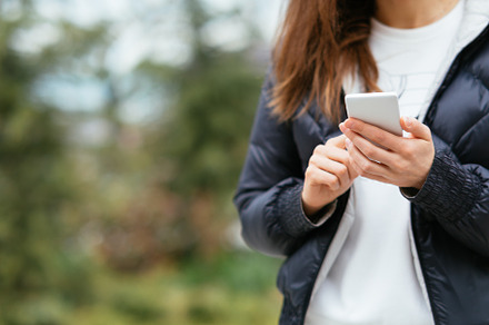 Close-up of young woman holding mobile phone in her hands, a Person Photo by progressman