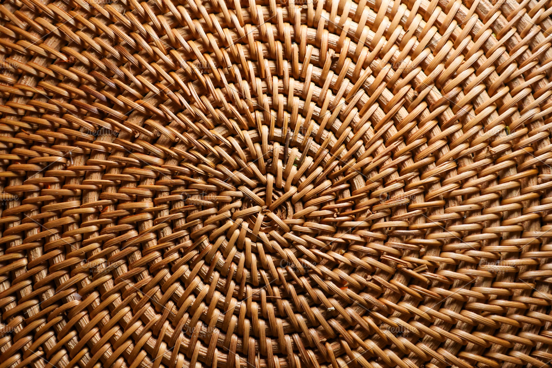 Wicker rattan craft showing intricate woven pattern and circular, a Photo by Studio ANNA