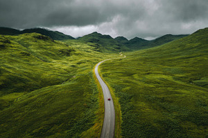 Curved road through green hills, a Photo by Beautiful things