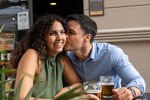 Young couple sharing affectionate moment at outdoor restaurant terrace with bee, a Person Photo by etorres69