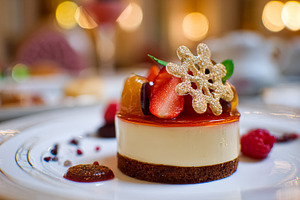 Gourmet cheesecake dessert presented on a white plate, featuring, a Food & Drink Photo by Studio ANNA