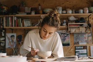 Teen girl painting ceramic, a Photo by Virgo Studio
