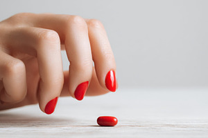 Person reaches for a red pill, a Photo by Beautiful things
