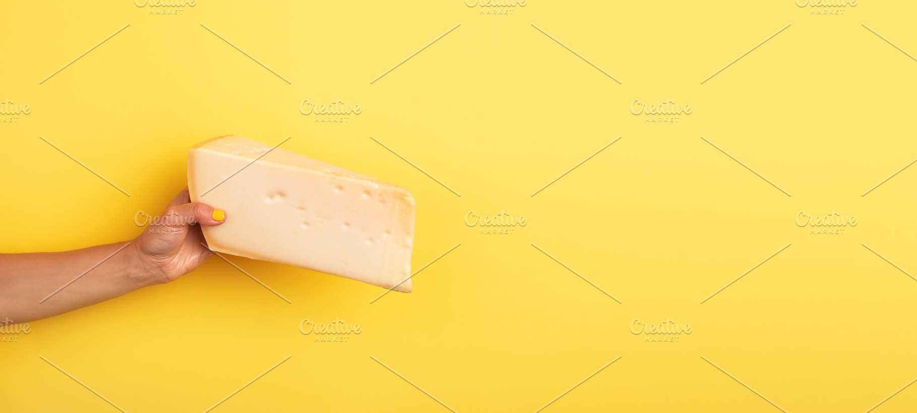Woman’s hand with yellow nail polish holding a large wedge of, a Food & Drink Photo by Ales Munt