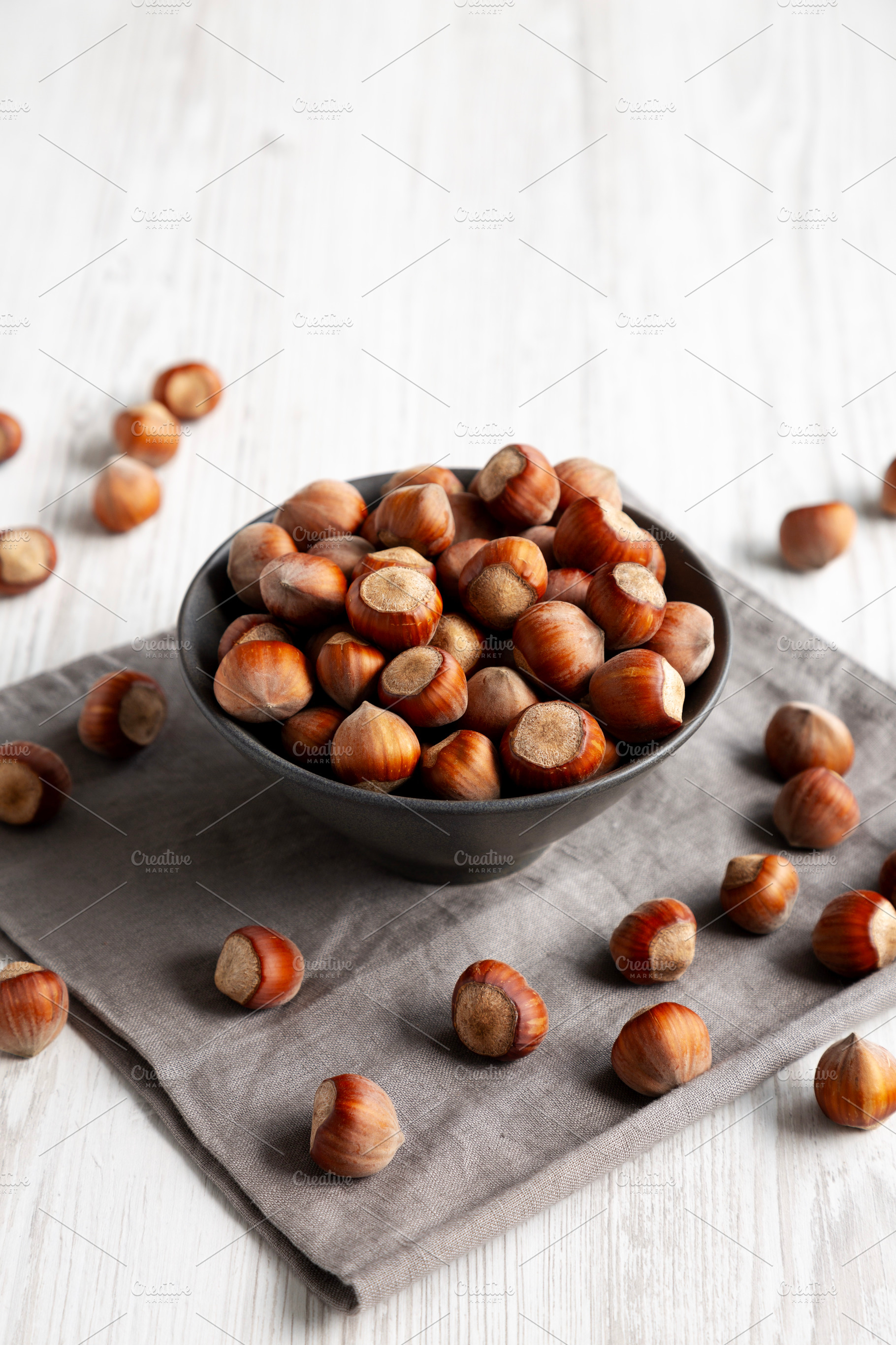 Organic Raw Hazelnuts in a Bowl, side view., a Food & Drink Photo by LiudmylaChuhunova