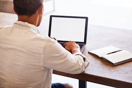 Laptop, mockup space and businessman doing research on the internet with technology in modern office. Corporate manager typing email, management project or company report on computer with copy space., a Photo by Peopleimages.com
