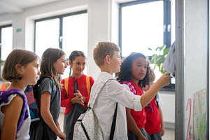 Group of schoolchildren looking at, a School & Education Photo by HalfPoint