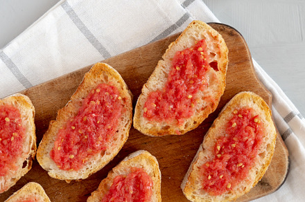 Homemade Pan Con Tomate (Tomato Toast) on a Rustic Wooden Board,, a Food & Drink Photo by LiudmylaChuhunova
