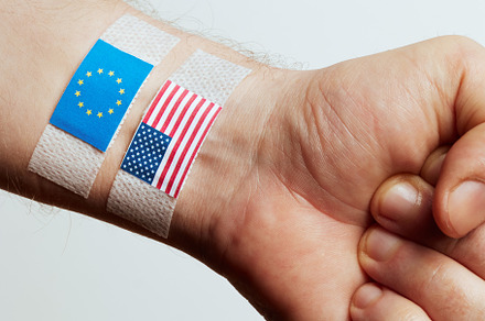 Wrist with EU and US Flags Representing Economic Conflict, a Business Photo by Alliance Images
