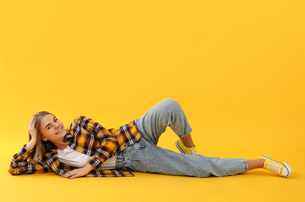 Young attractive girl in checkered shirt on yellow background, a Person Photo by AtlasStudio PRO