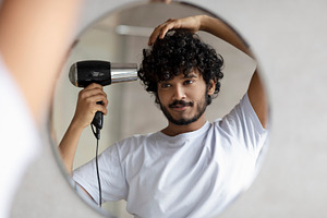 Handsome indian man drying hair after shower, making hairdo, taking care of him, a Person Photo by Prostock-Studio